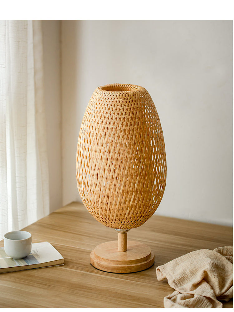 Lampe de chevet en rotin et bambou tissé oval présenté sur une table en bois