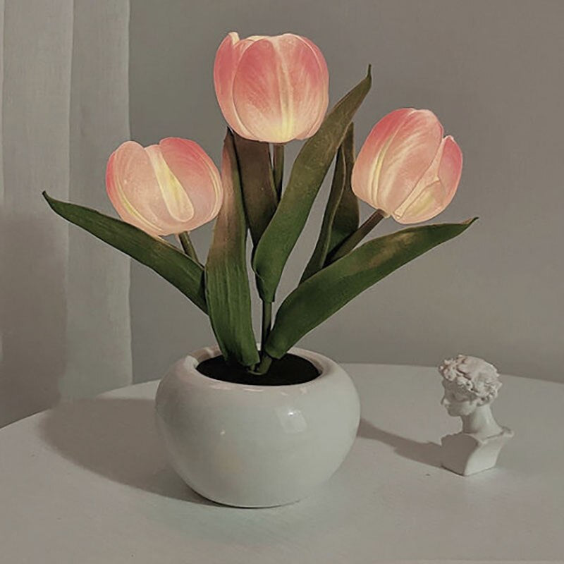 Lampe fleur design LED 3 tulipes roses ou jaunes rose, présentées dans un vase blanc posée sur une table