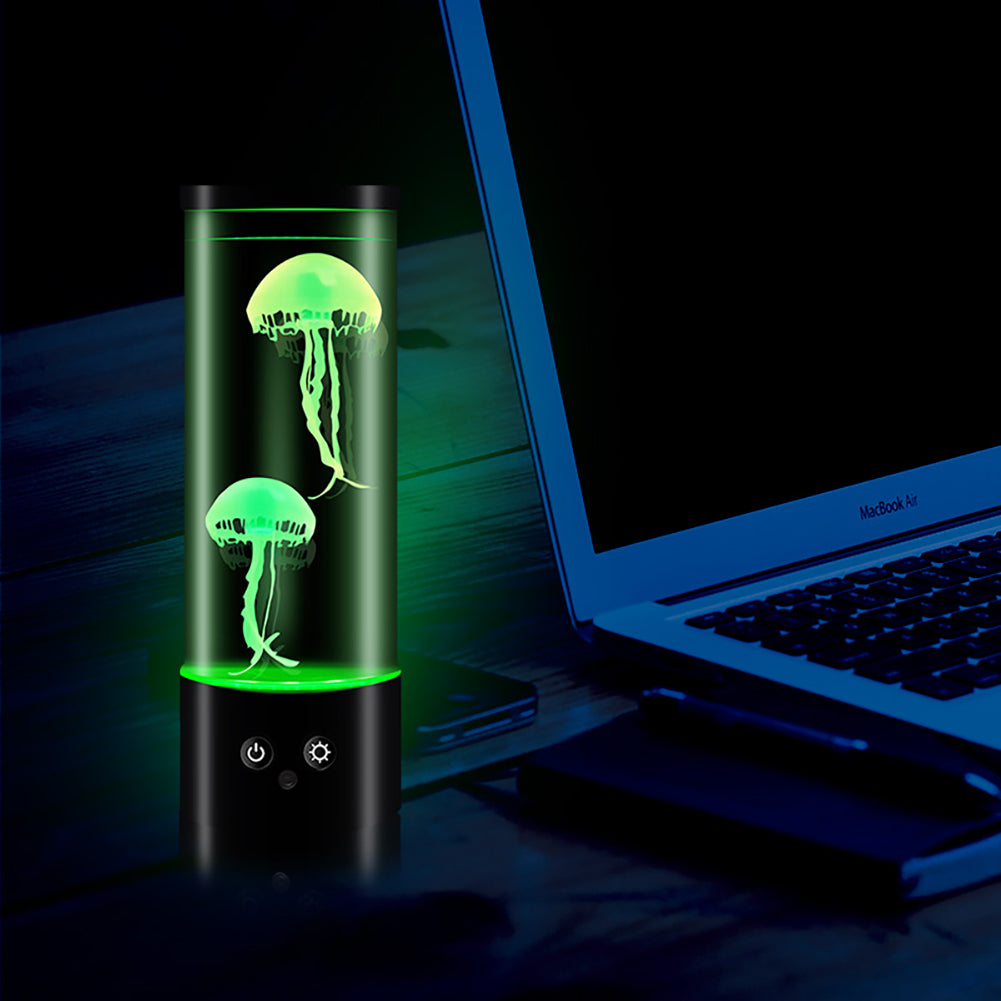 Lampe méduse LED cylindrique avec télécommande sur fond d'un bureau et d'un ordinateur la nuit
